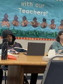 a group of people sit at a table with a sign that says with our teachers