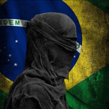 a person covering their face in front of a flag that says " ordem "