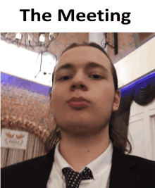 a picture of a man in a suit and tie with the words the meeting above him