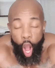 a man with a beard is making a funny face with his mouth open .