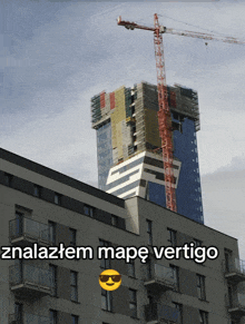 a building with a crane on top of it and the words malazem mape vertigo on the bottom