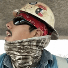 a man wearing a hard hat sunglasses and a bandana has a sticker on his hard hat that says ' texas '