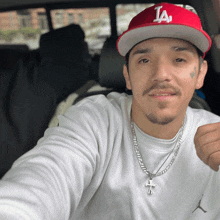 a man wearing a la hat and a necklace