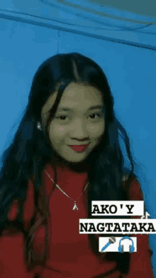 a girl with long hair is wearing a red sweater and a necklace .