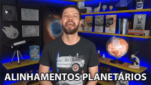 a man wearing a back to the future t-shirt stands in front of a shelf full of books and a globe