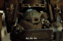 a baby yoda says " no. no. no. " while sitting inside of a robot