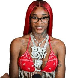 a woman with red hair and glasses is wearing a red bikini top and a big sexy necklace