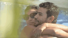 a man and a woman are hugging in a pool .