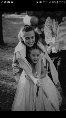 a little girl in a white dress is being pulled by a woman in a white dress