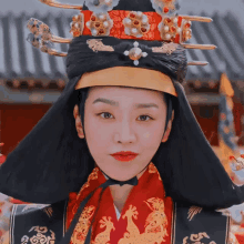 a woman wearing a red and black costume and a black hat