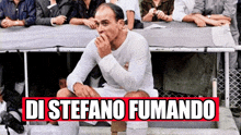 a man in a white shirt is smoking a cigarette with the words di stefano fumando written below him