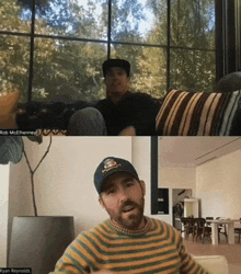 two men are sitting on a couch and having a video call .