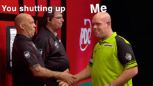 two men shaking hands in front of a sign that says " you shutting up me "