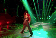 a woman is dancing in a dark room with green lights