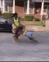 a woman is pushing a child on a skateboard down a street with the caption " asi te voy agarrar "