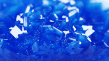 a close up of a pile of blue crystals on a white surface