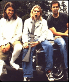 a man with a gun in his mouth is sitting next to two other men