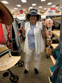 an elderly woman in a hat stands in front of a sign that says 50 % off