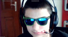 a young man wearing headphones and sunglasses is recording a video