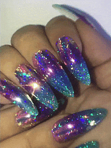 a close up of a woman 's nails with a purple and blue design