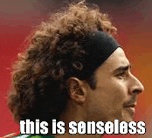 a man with curly hair wearing a headband and the words `` this is senseless '' written on it .