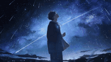 a man is looking up at the night sky with stars falling from the sky