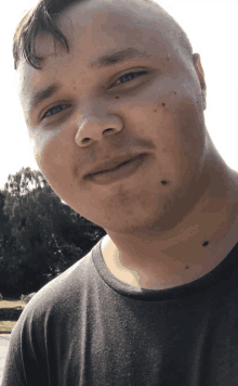 a close up of a man 's face with a black shirt on