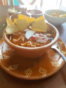 a bowl of soup with tortilla chips on top of it