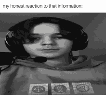 a black and white photo of a young man wearing headphones and a shirt that says " my honest reaction to that information "