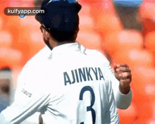 a man wearing a white jersey with the number 3 on it is standing in front of a stadium .