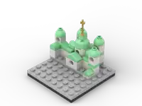 a lego model of a castle with green roofs and a gold cross on top