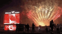 a large fireworks display is going off in front of a stadium that says akron stadium