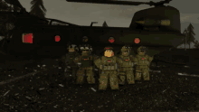 a group of soldiers standing in front of a green helicopter