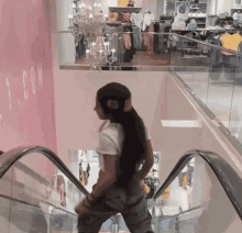 a woman with long hair is riding an escalator in a store .