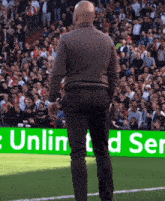 a man stands on a soccer field in front of a green sign that says " unlin d ser "