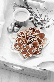 a black and white photo of gingerbread cookies and a cup of coffee .