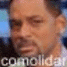 a blurry picture of a man 's face with the words `` comolidar '' written on it .