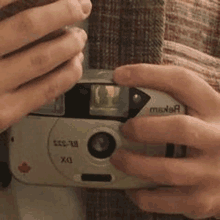 a person is holding a camera in their hand and taking a picture .