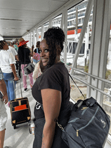 a woman wearing a black shirt with the letter s on it smiles