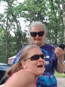 two older women wearing sunglasses and a shirt that says always