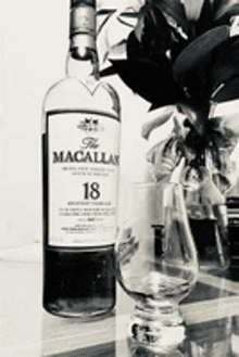 a bottle of macallan whiskey is sitting next to a glass on a table .