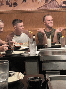 a group of people are sitting at a table with a bottle of beer that says ' pacific ' on it