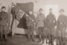 a black and white photo of soldiers holding a flag