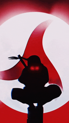 a silhouette of a person with red eyes in front of a red circle