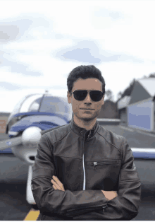 a man wearing sunglasses is standing in front of a plane