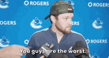 a man talking into a microphone with the words " you guys are the worst "