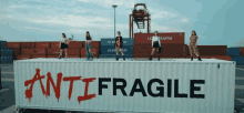 a group of women standing on top of a container that says antifragile