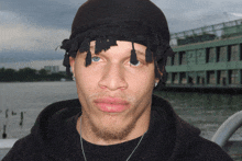 a man wearing a black hoodie and a black headband looks at the camera