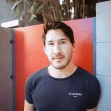 a man with a beard is standing in front of a colorful wall .