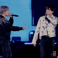 two men singing into microphones with the words kook hope gifs on the bottom right